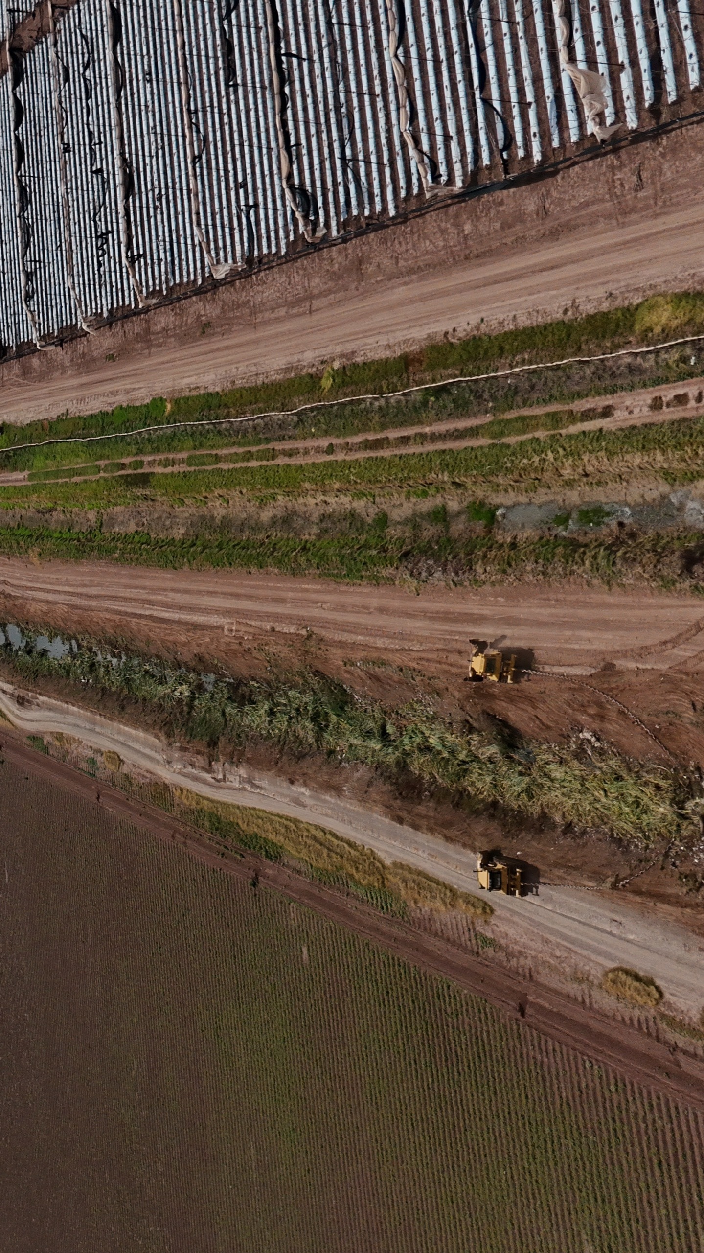 Canal lateral junto a parcelas e invernaderos durante la conservación, 1 de septiembre de 2026.