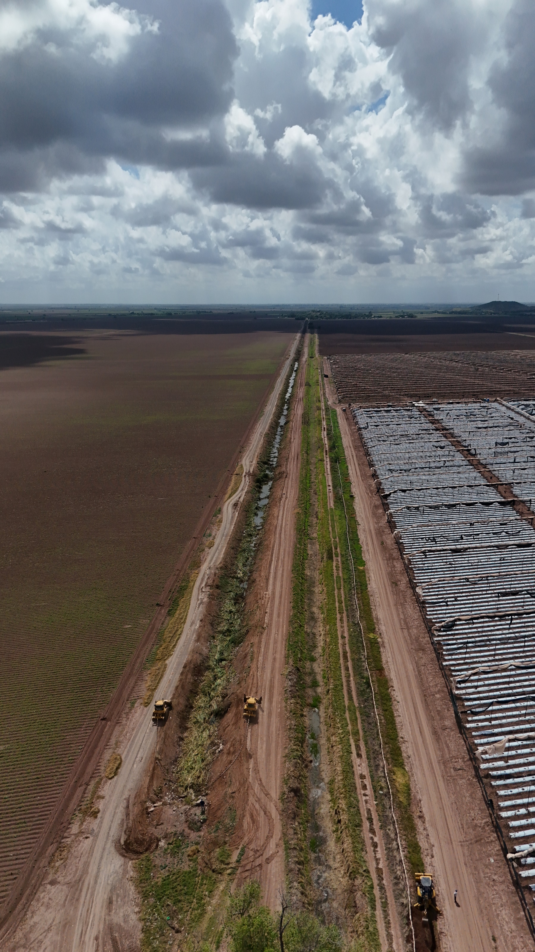 Vista vertical del canal, camino de servicio y zona de invernaderos, 1 de septiembre de 2026.
