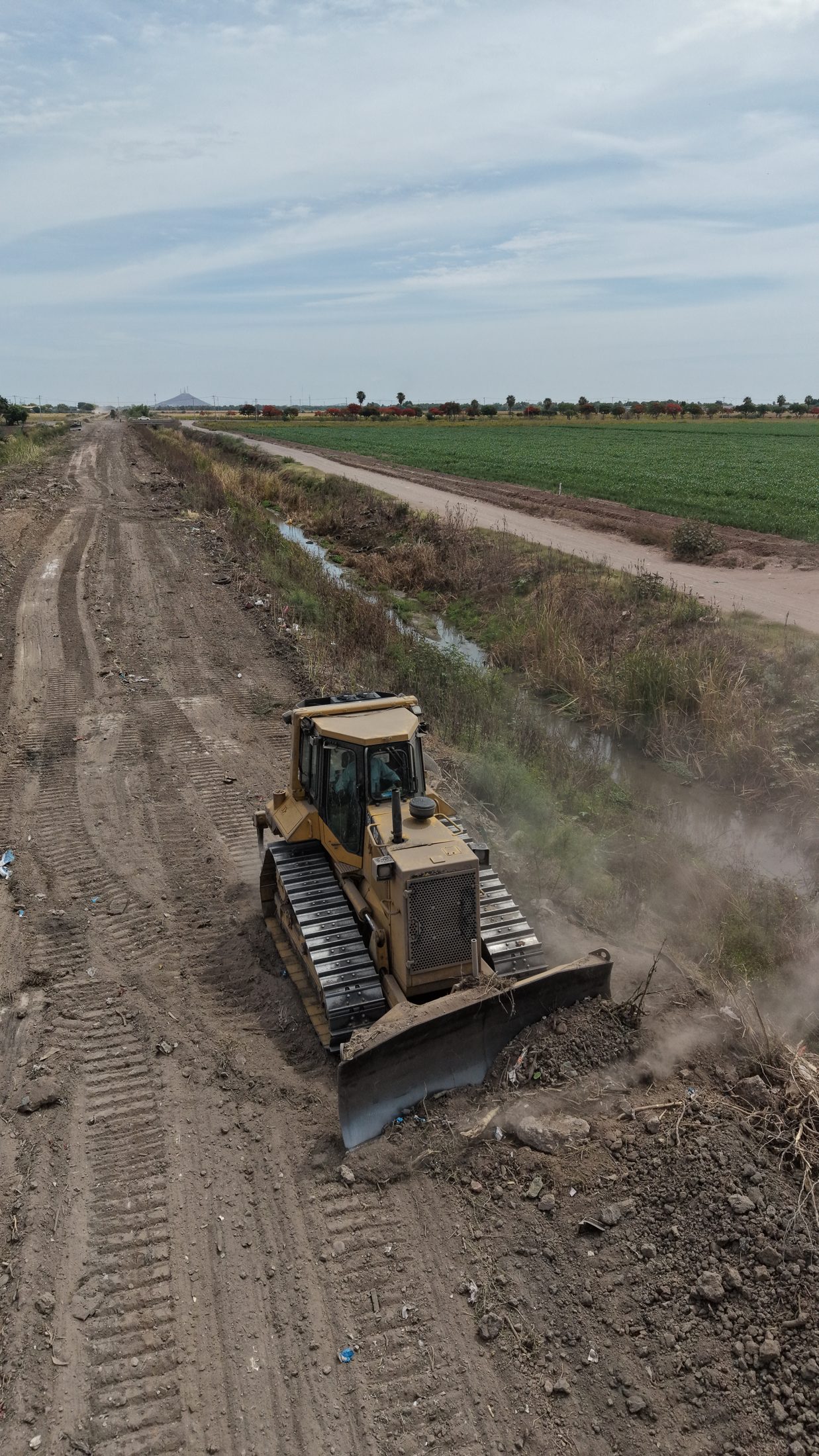 Vista vertical de un bulldozer sobre el camino de conservación junto al canal, 25 de mayo de 2026.