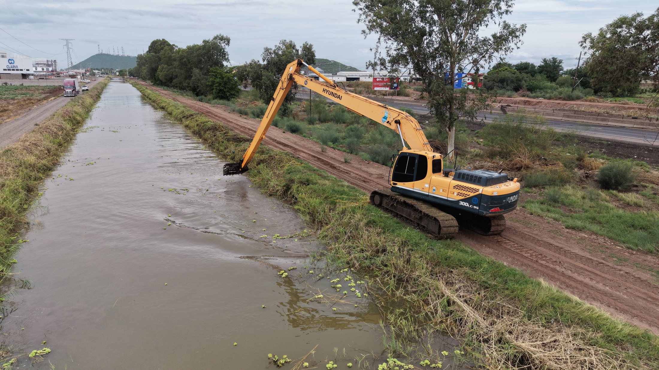 Operación sobre lateral activo. Vista longitudinal del canal con equipo trabajando desde el bordo.