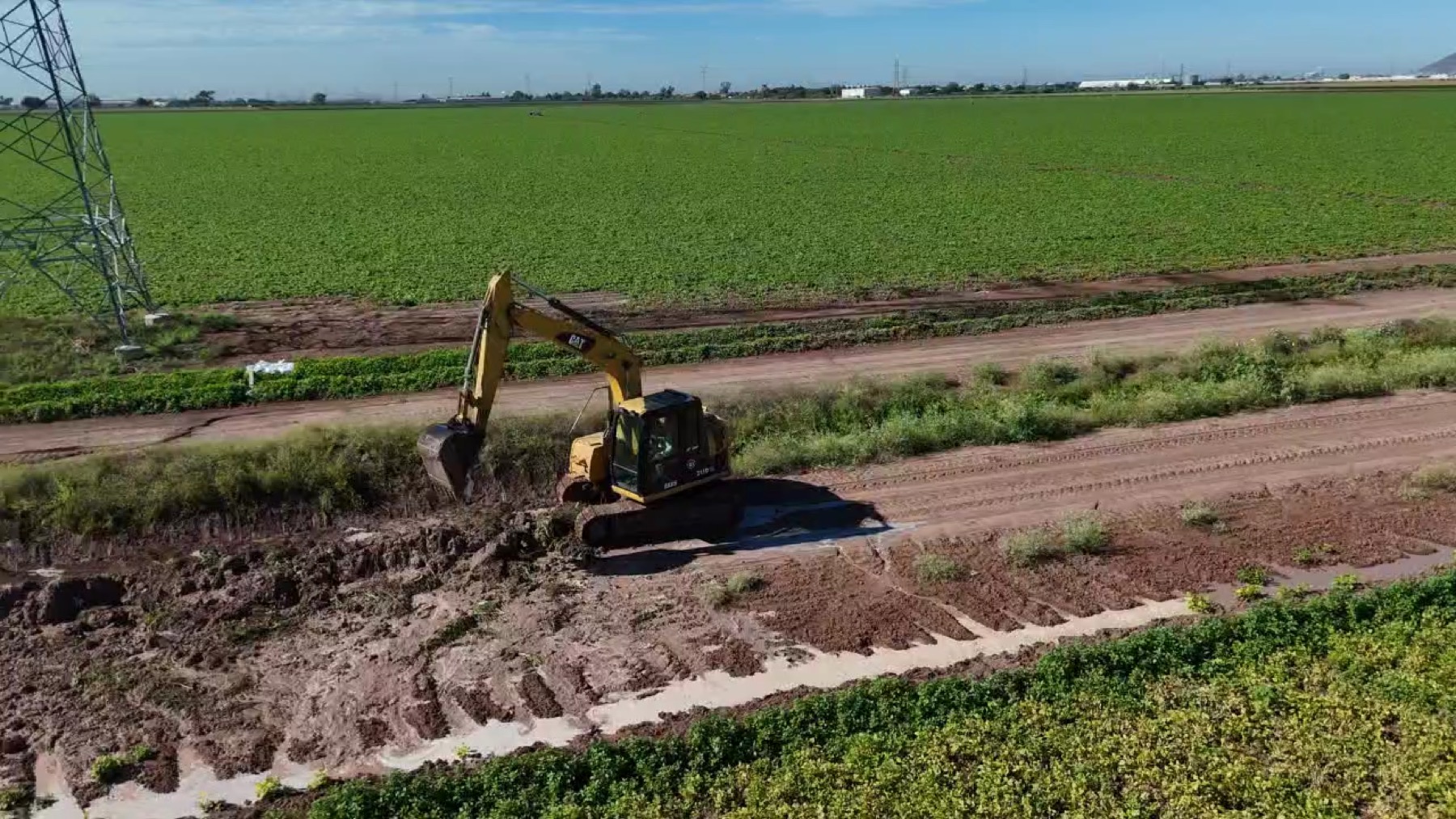 Vista aérea de canal de riego junto a parcelas cultivadas, 28 de enero de 2026.