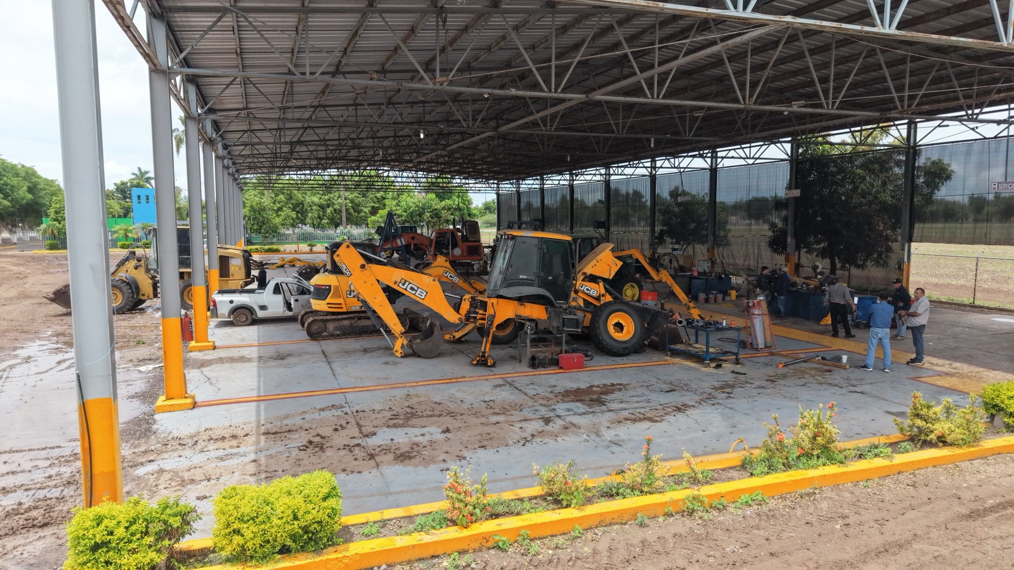 Retroexcavadoras JCB resguardadas en el taller del módulo, agosto de 2026.